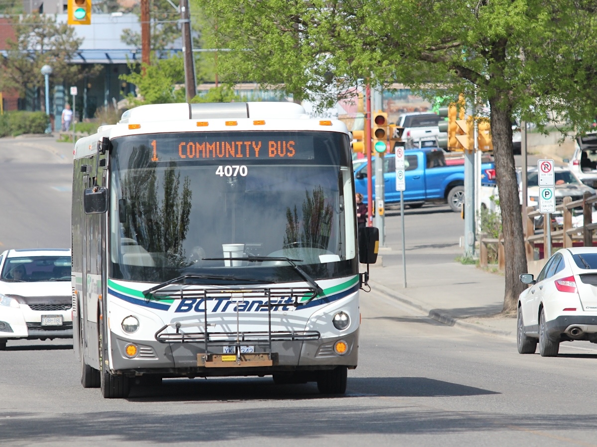 A BC Transit bus drives through the centre of Williams Lake. The display sign above the front window says &lsquo;1 Community Bus.&rsquo;